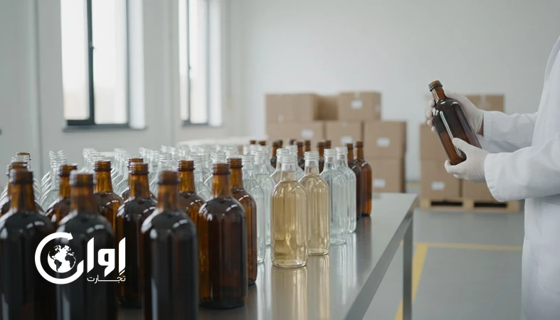 عرق کاسنی در بطری شیشه‌ای شفاف و کهربایی روی میز کنترل کیفیت قبل از بارگیری صادراتی